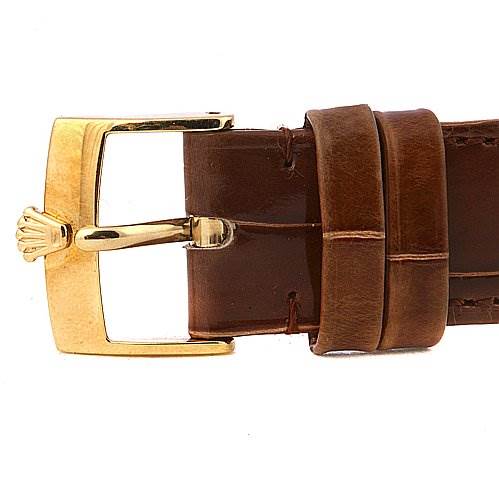 The image shows a close-up of the brown leather strap and gold buckle with the Rolex logo for the Cellini model by Rolex.