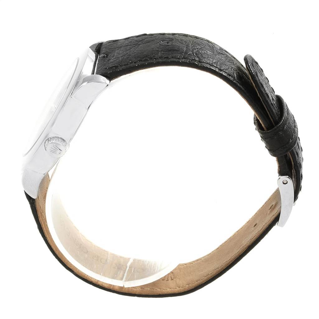 The image shows a side view of a Rolex Cellini 5240/9 Men's Platinum Mother of Pearl Dial 5240/9 Men's Platinum Mother of Pearl Dial watch, focusing on the case, crown, and black leather strap.