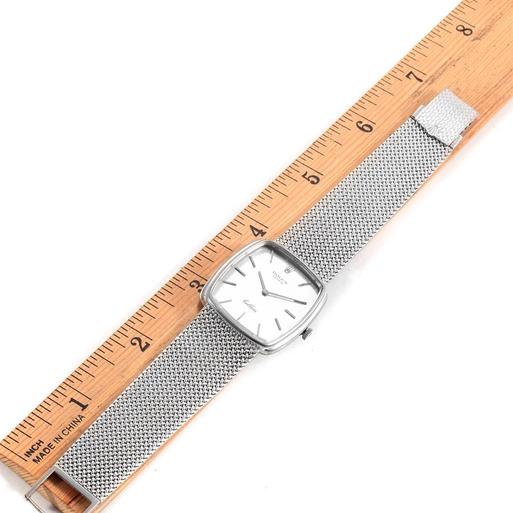 The Rolex Cellini 4086 Men's White Gold Silver Dial 4086 Men's White Gold Silver Dial watch is shown from a top-down angle, revealing its face and metal mesh strap, placed next to a ruler.