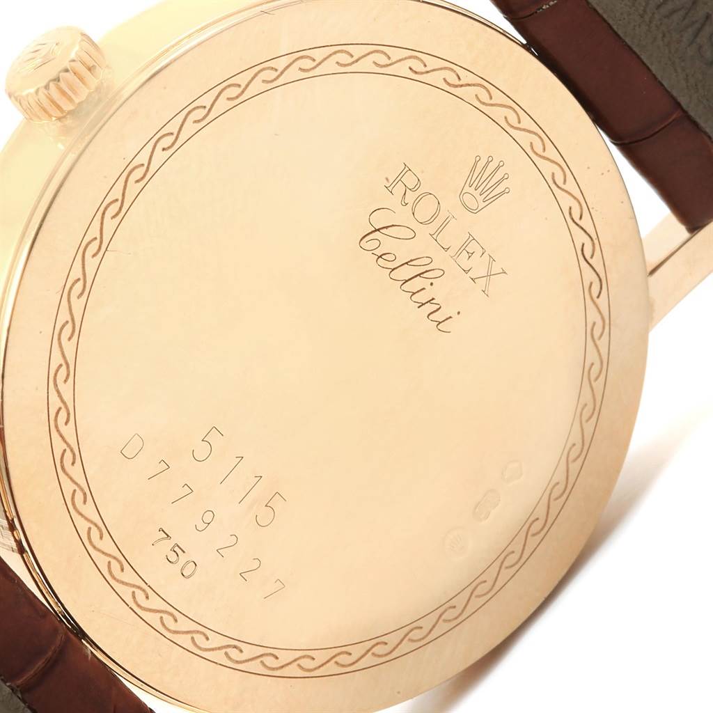 The image shows the back case of a Rolex Cellini 5115 Men
s Yellow Gold Champagne Dial 5115 Men
s Yellow Gold Champagne Dial watch, highlighting the engravings and part of the leather strap.