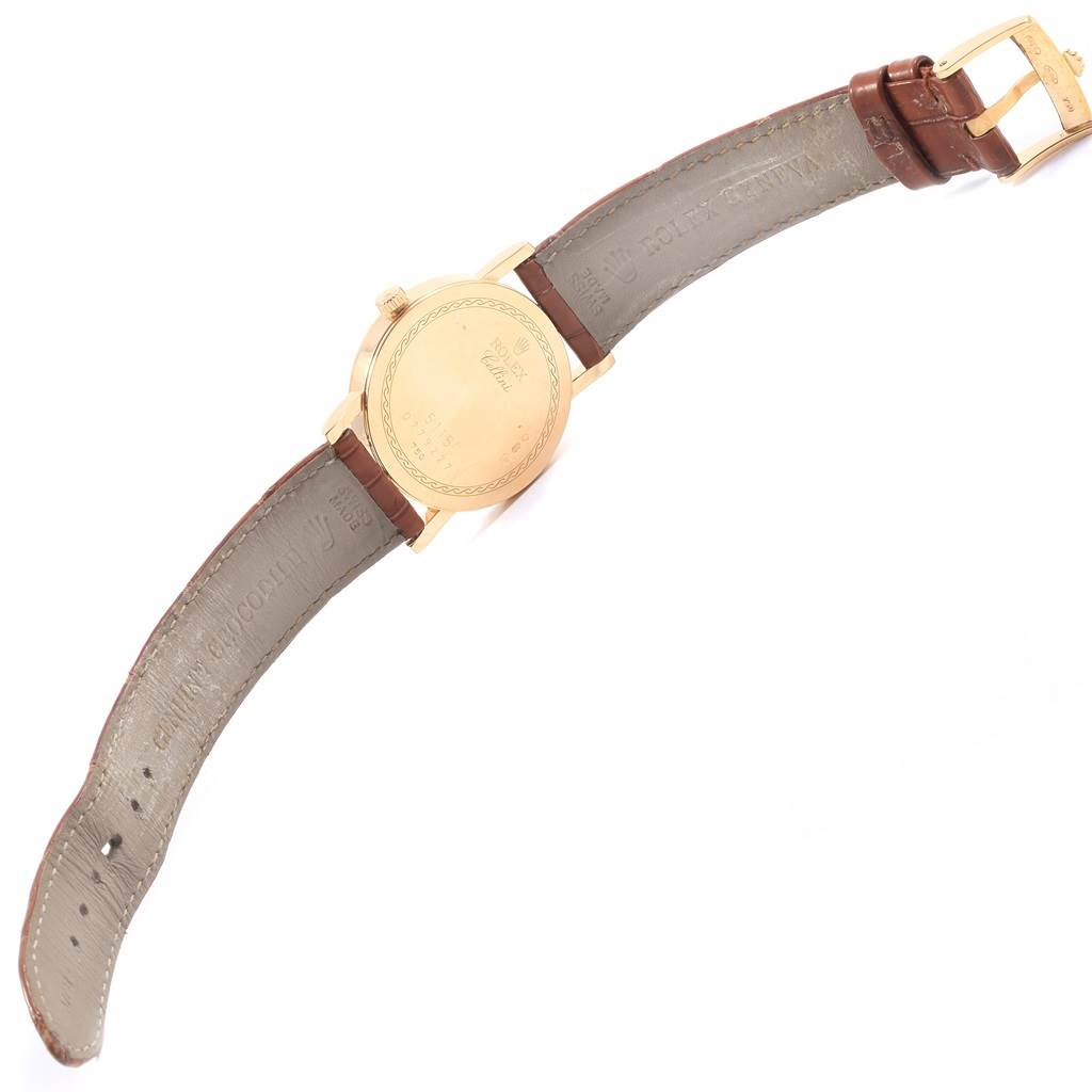 The image shows the back case and leather strap of a Rolex Cellini 5115 Men
s Yellow Gold Champagne Dial 5115 Men
s Yellow Gold Champagne Dial watch from a top-down angle.