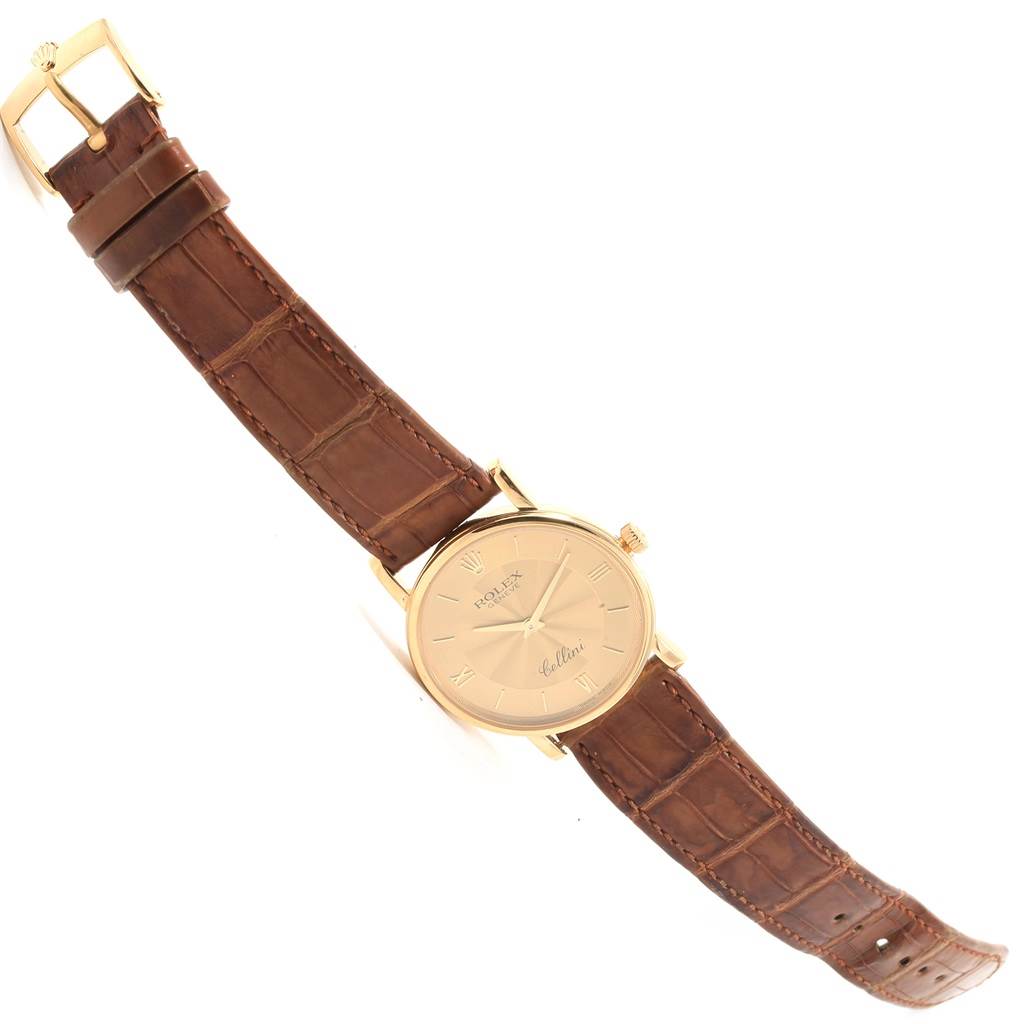 The Rolex Cellini 5115 Men
s Yellow Gold Champagne Dial 5115 Men
s Yellow Gold Champagne Dial watch is displayed at an angle showing the full face, leather strap, buckle, and crown.