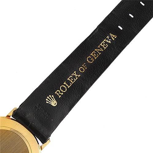 The image shows a partial view of a Rolex Cellini 4112 Men's Yellow Gold White Dial 4112 Men's Yellow Gold White Dial watch, focusing on the black leather strap with "Rolex of Geneva" branding.