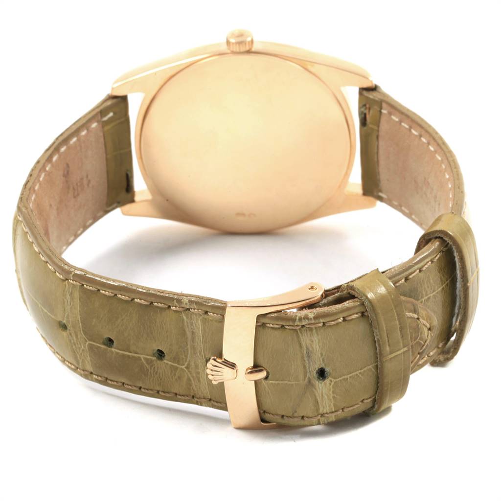 The image shows a rear view of a Rolex Cellini 4233 Men's Yellow Gold White Dial 4233 Men's Yellow Gold White Dial watch, focusing on the gold case back and beige leather strap with a gold buckle.