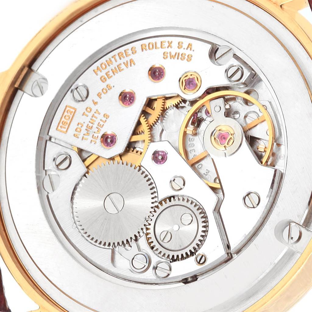 The image shows the intricate inner movement of a Rolex Cellini 5115 Men
s Yellow Gold Grey Dial 5115 Men
s Yellow Gold Grey Dial watch, focusing on the gears and mechanisms.