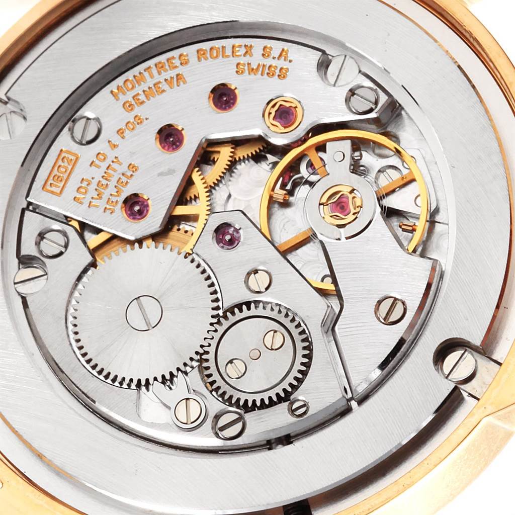 The image shows the intricate internal mechanism of a Rolex Cellini 5116 Men's Yellow Gold Champagne Dial 5116 Men's Yellow Gold Champagne Dial watch, highlighting gears, jewels, and inscriptions.