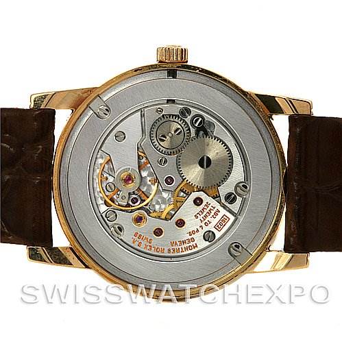 The image shows the back view of the Rolex Cellini 5116 Yellow Gold Silver Dial 5116 Yellow Gold Silver Dial watch, revealing its internal mechanical movement and gears.