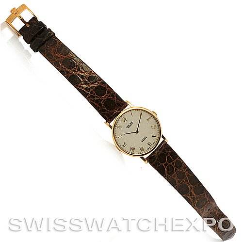 The Rolex Cellini 5112 Yellow Gold Beige Dial 5112 Yellow Gold Beige Dial watch is shown from a top-down angle, displaying its brown leather strap and gold case with a white dial.