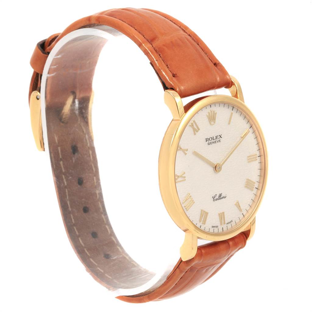 The image shows a side view of a Rolex Cellini 5112 Men
s Yellow Gold Beige Dial 5112 Men
s Yellow Gold Beige Dial watch with a brown leather strap and a gold case.