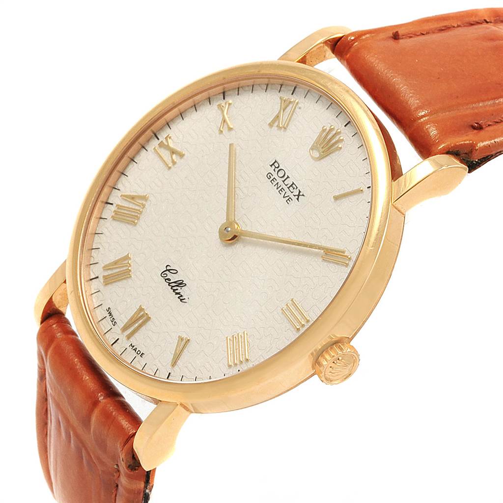 This Rolex Cellini 5112 Men
s Yellow Gold Beige Dial 5112 Men
s Yellow Gold Beige Dial watch is shown at an angled close-up, displaying its white dial, gold indices, case, and brown leather strap.