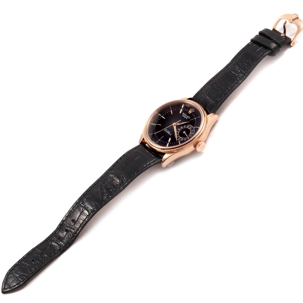 The Rolex Cellini 50515 Men
s Rose Gold Black Dial 50515 Men
s Rose Gold Black Dial watch is shown from a slight top-down angle, highlighting the black leather strap and gold case.