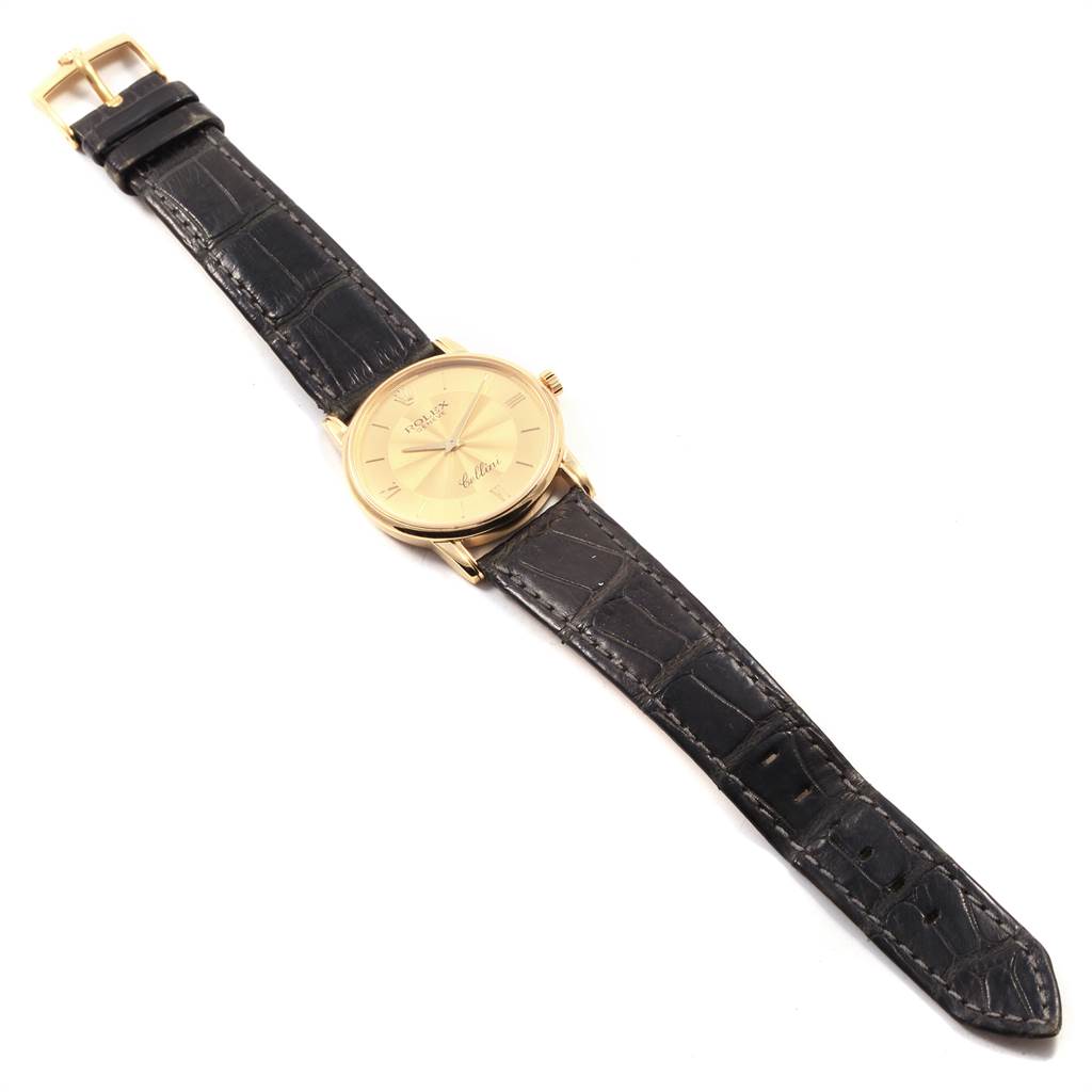 The Rolex Cellini 5116 Men's Yellow Gold Champagne Dial 5116 Men's Yellow Gold Champagne Dial watch is shown from a top-down angle, displaying the face, bezel, crown, and entire black leather strap.