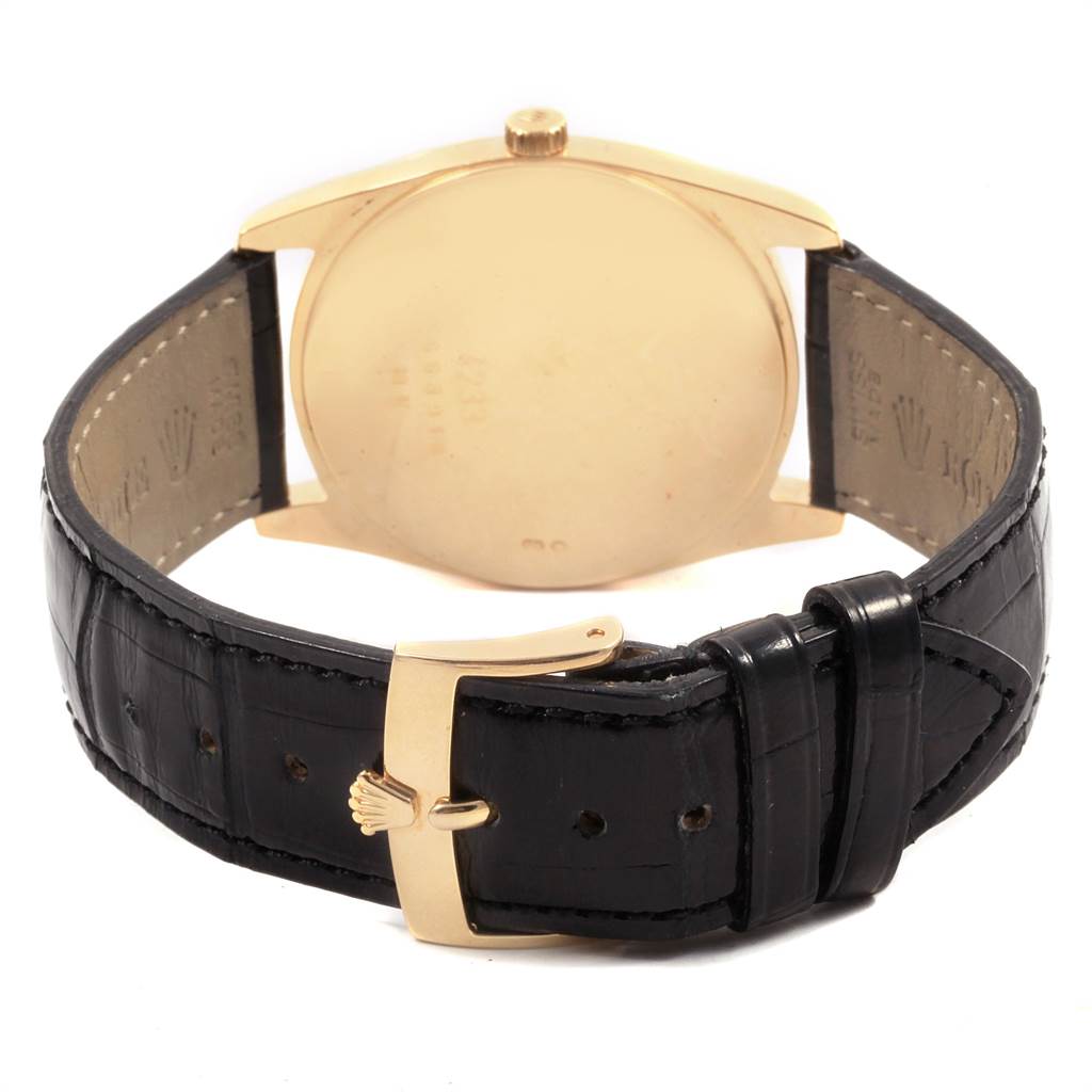 The image shows the back of a Rolex Cellini 4233 Men's Yellow Gold White Dial 4233 Men's Yellow Gold White Dial watch, including its gold case and black leather strap with a gold buckle.