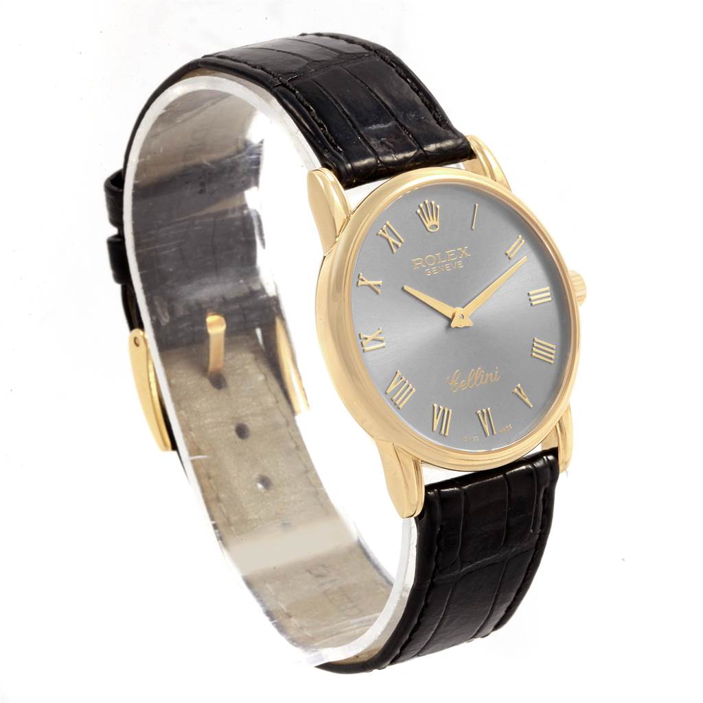 This Rolex Cellini 5116 Men's Yellow Gold Grey Dial 5116 Men's Yellow Gold Grey Dial watch is shown at an angled view featuring its face, black leather strap, gold casing, and crown.