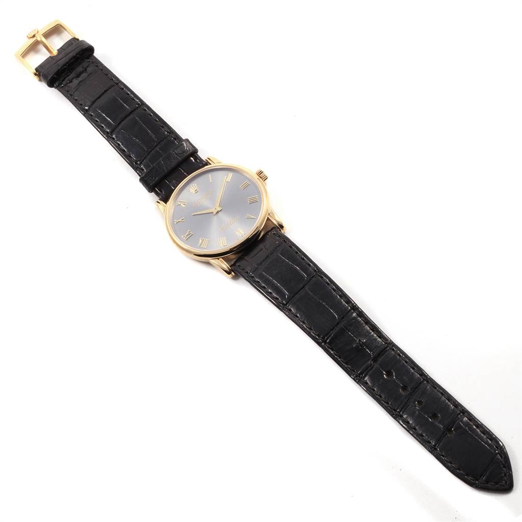 The Rolex Cellini 5116 Men's Yellow Gold Grey Dial 5116 Men's Yellow Gold Grey Dial watch is shown from a top-down angle, displaying its full face, bezel, and black leather strap.