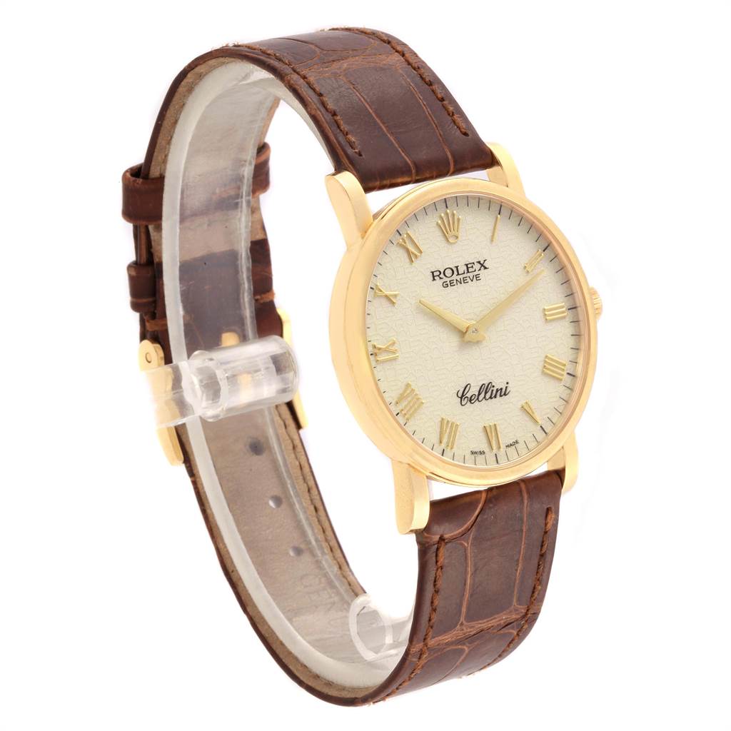 The Rolex Cellini 5115 Men's Yellow Gold Beige Dial 5115 Men's Yellow Gold Beige Dial watch is shown at an angled side view, detailing its gold case, white dial, and brown leather strap.