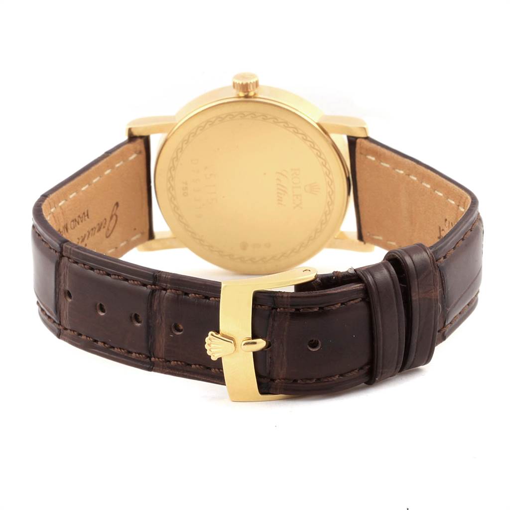 The image shows the back view of a Rolex Cellini 5115 Men's Yellow Gold Champagne Dial 5115 Men's Yellow Gold Champagne Dial watch, highlighting its gold case and brown leather strap with a gold buckle.