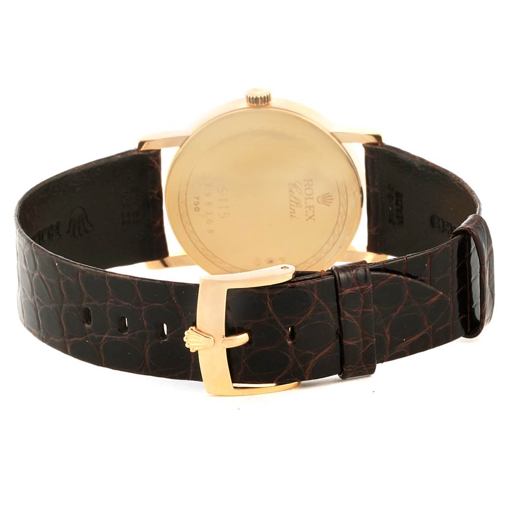 The image shows the back side of the Rolex Cellini 5115 Men's Yellow Gold Beige Dial 5115 Men's Yellow Gold Beige Dial watch, including its golden case and leather strap with a golden buckle.