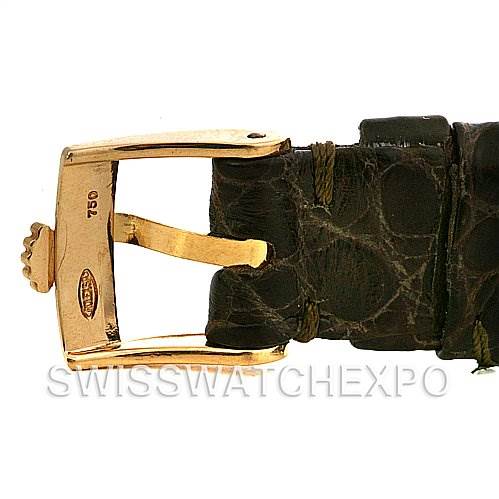 The image shows a close-up of a Rolex Cellini 4015 Yellow Gold Brown Dial 4015 Yellow Gold Brown Dial watch's gold buckle and leather strap.