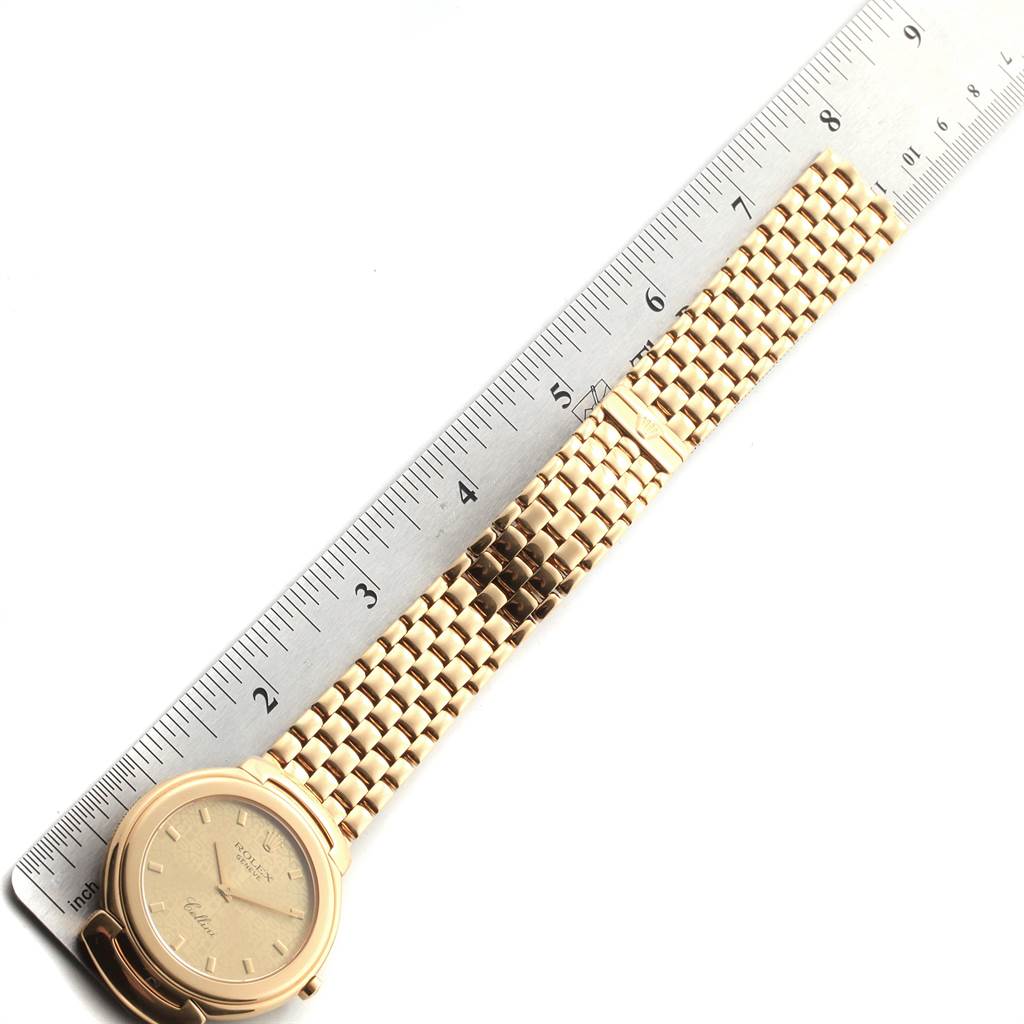 The image shows a Rolex Cellini 6623 Men
s Yellow Gold Champagne Dial 6623 Men
s Yellow Gold Champagne Dial watch viewed from above, displaying the face, bezel, and entire bracelet next to a ruler.