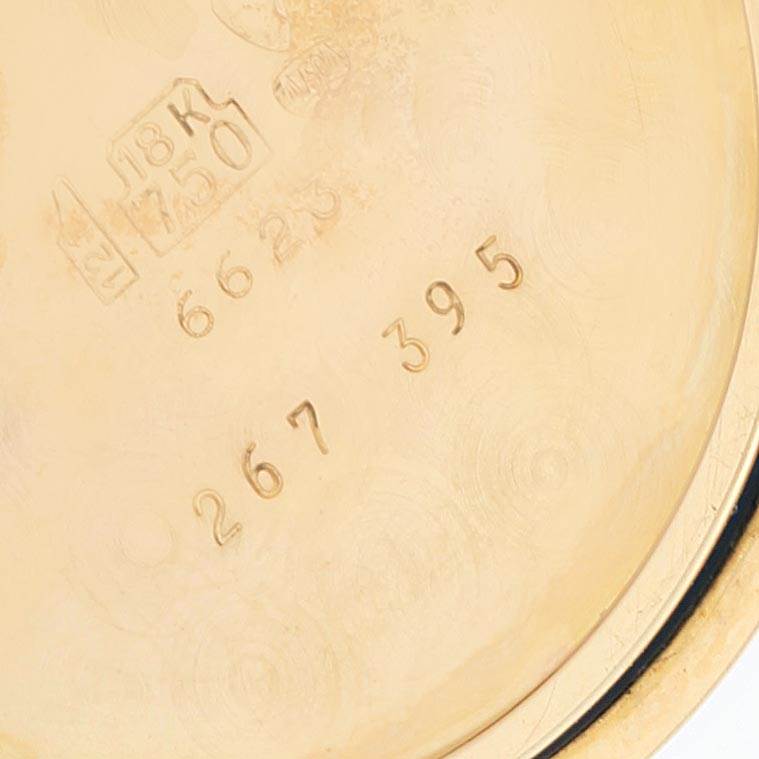 This is a close-up of the inner case back of a Rolex Cellini 6623 Men
s Yellow Gold Champagne Dial 6623 Men
s Yellow Gold Champagne Dial watch, showing engravings and hallmark stamps.