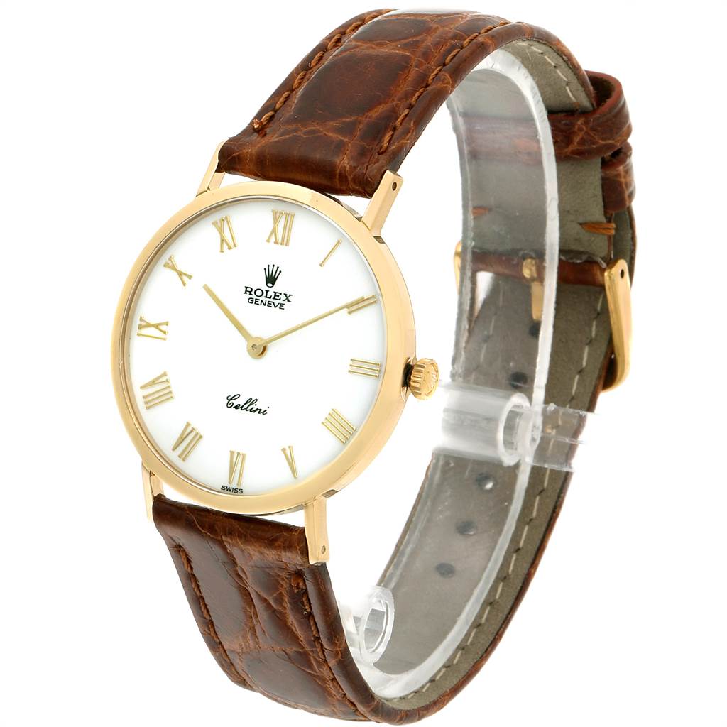 The image shows a side and front angle of a Rolex Cellini 4112 Men
s Yellow Gold White Dial 4112 Men
s Yellow Gold White Dial watch, showcasing its dial, crown, and brown leather strap.