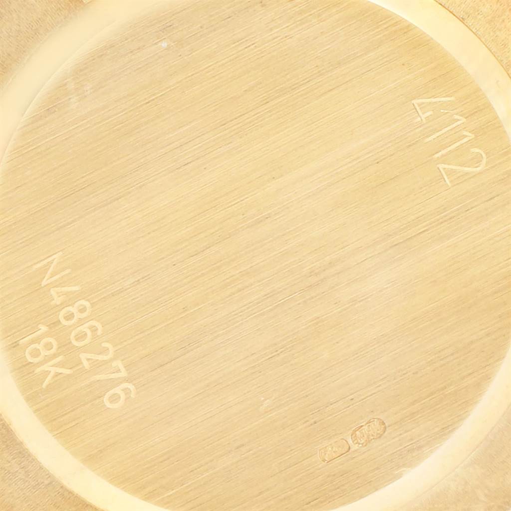 This image shows the case back of a Rolex Cellini 4112 Men's Yellow Gold White Dial 4112 Men's Yellow Gold White Dial watch from an angled close-up view, highlighting the engravings and 18K gold material.