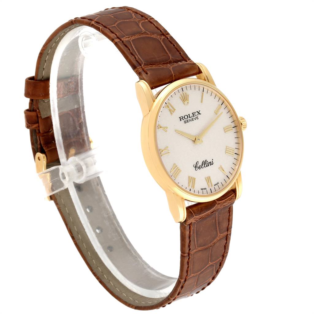 The Rolex Cellini 5116 Men's Yellow Gold Beige Dial 5116 Men's Yellow Gold Beige Dial watch is shown at a three-quarter angle, displaying its face, gold case, and brown leather strap.