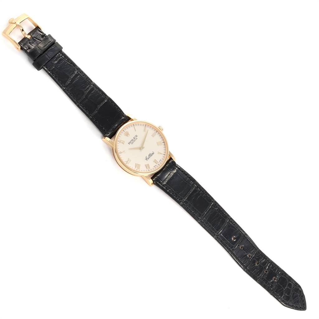 The image shows a top-down view of a Rolex Cellini 5115 Men's Yellow Gold Beige Dial 5115 Men's Yellow Gold Beige Dial watch with a black leather strap and a gold buckle.