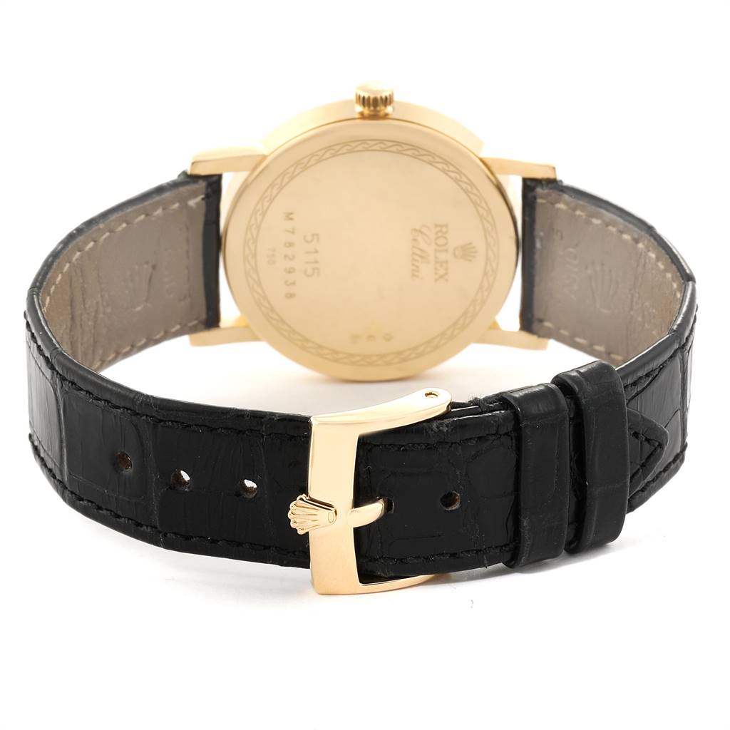 The image shows the back of a Rolex Cellini 5115 Men's Yellow Gold Beige Dial 5115 Men's Yellow Gold Beige Dial watch with its black leather strap and gold buckle visible.