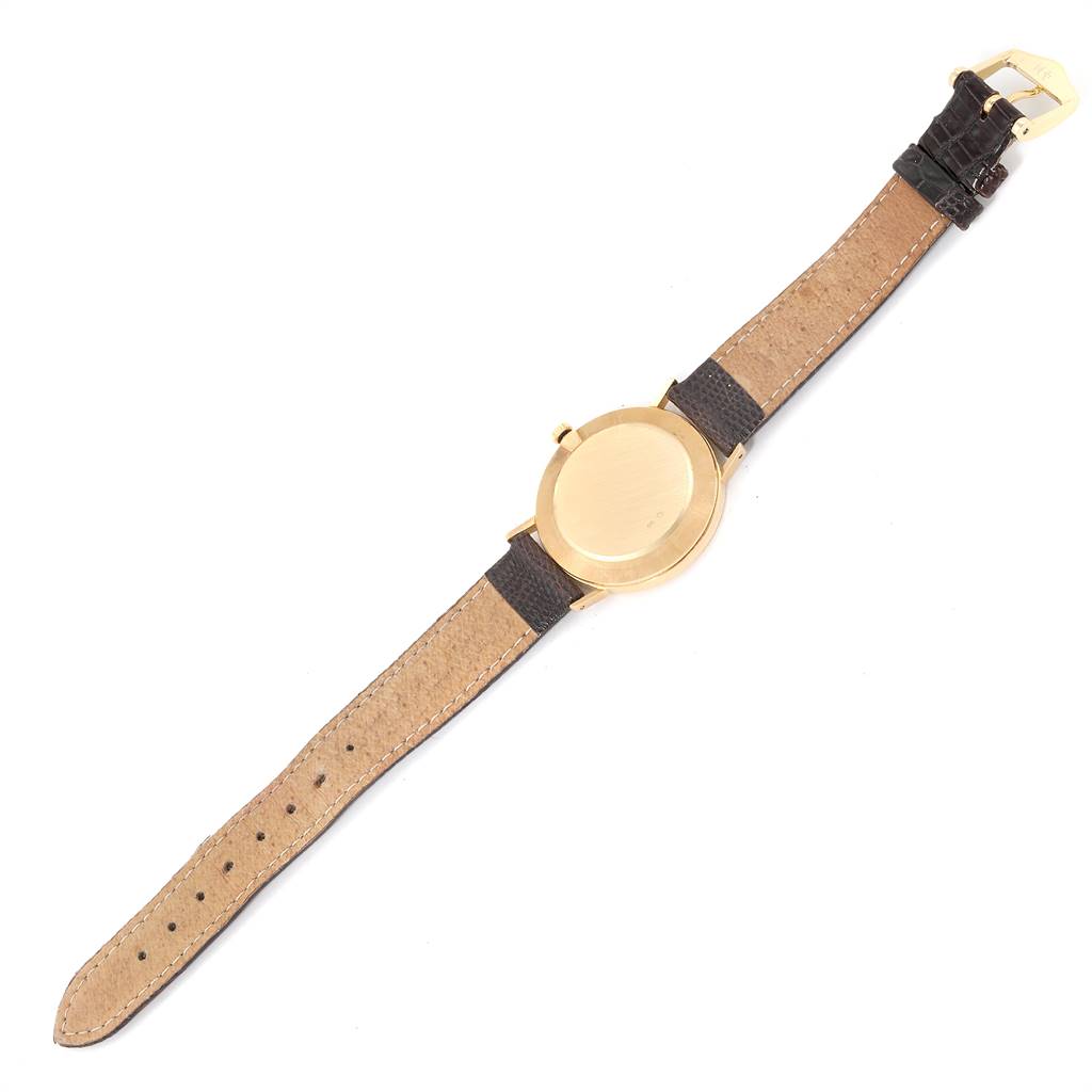 The image shows a Rolex Cellini 4112 Men's Yellow Gold Champagne Dial 4112 Men's Yellow Gold Champagne Dial watch from the back, highlighting its gold case and leather strap.