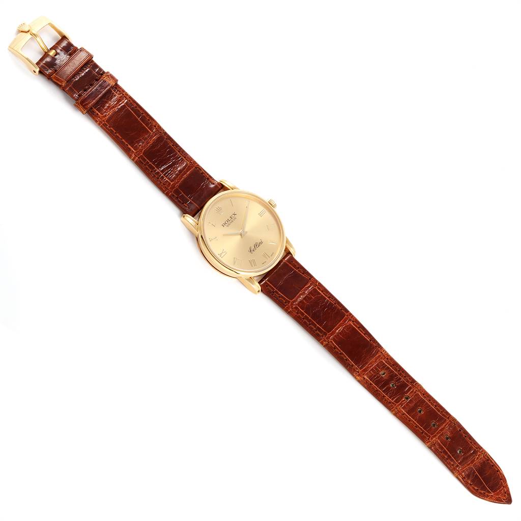 The image shows a Rolex Cellini 5116 Men's Yellow Gold Champagne Dial 5116 Men's Yellow Gold Champagne Dial watch from a top-down angle, highlighting its gold dial and brown leather strap.