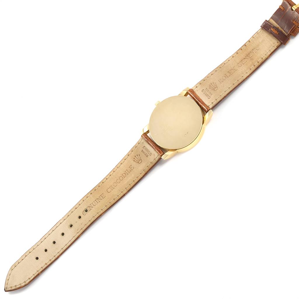 The image shows the back of a Rolex Cellini 5116 Men's Yellow Gold Champagne Dial 5116 Men's Yellow Gold Champagne Dial watch and its leather strap, displaying the caseback and inner sides of the band.