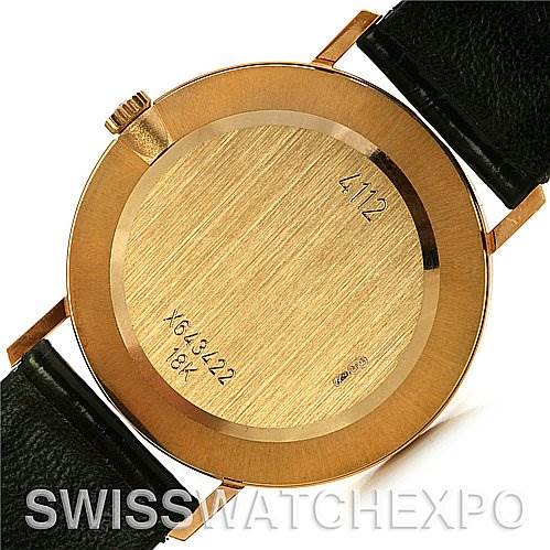 This image shows the backside of a Rolex Cellini 4112 Yellow Gold White Dial 4112 Yellow Gold White Dial watch, highlighting its case back with inscriptions and crown, and attached black leather straps.