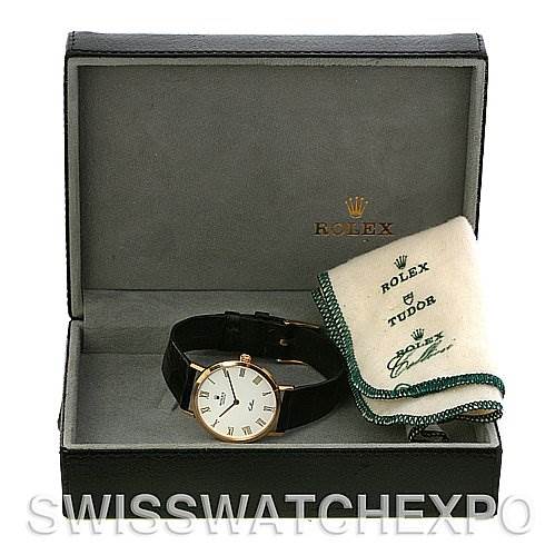 The image shows a Rolex Cellini 4112 Yellow Gold White Dial 4112 Yellow Gold White Dial watch with a leather band placed in an open Rolex box along with a branded cleaning cloth.