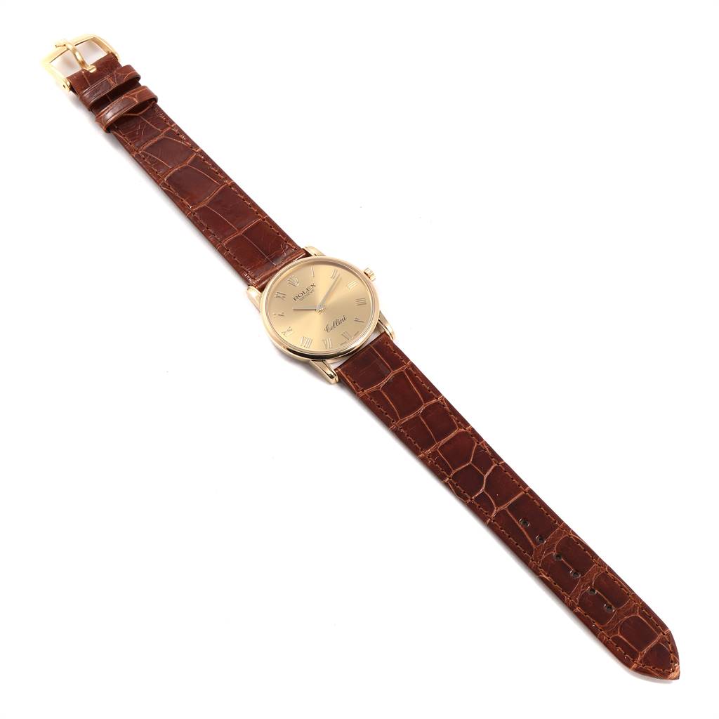 The image shows a Rolex Cellini 5116 Men's Yellow Gold Champagne Dial 5116 Men's Yellow Gold Champagne Dial watch laid flat, showcasing its brown leather strap and gold dial from a top-down view.