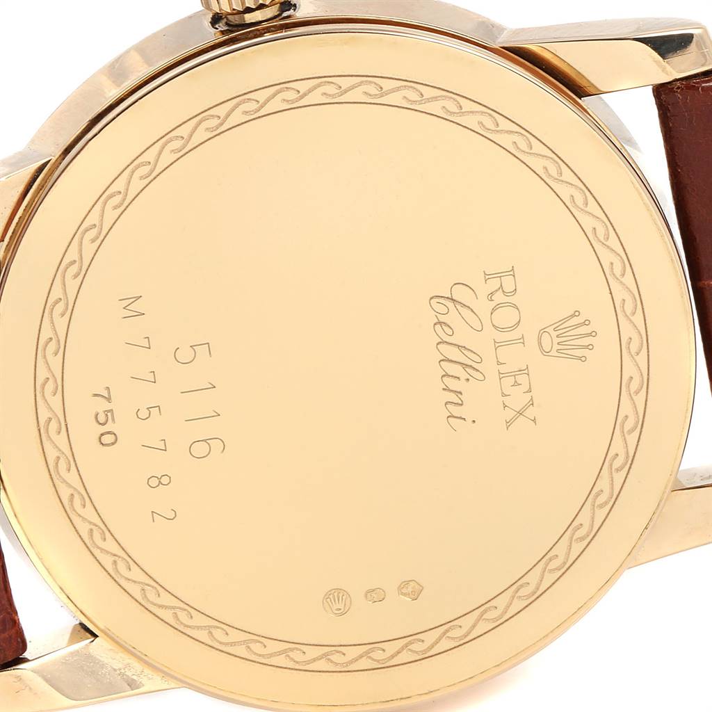 The image shows the back case of a Rolex Cellini 5116 Men's Yellow Gold Champagne Dial 5116 Men's Yellow Gold Champagne Dial model watch, highlighting the engraved details and the leather strap attachment.