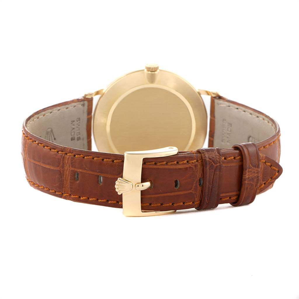 The image shows the back view of a Rolex Cellini 5112 Men's Yellow Gold Beige Dial 5112 Men's Yellow Gold Beige Dial watch, highlighting its gold case and brown leather strap with a buckle.