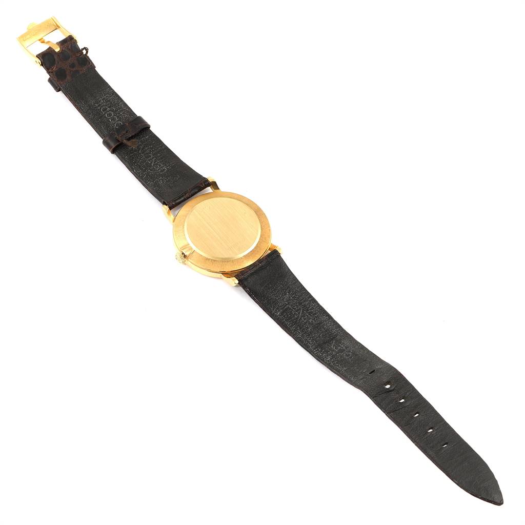 The Rolex Cellini 5112 Men's Yellow Gold White Dial 5112 Men's Yellow Gold White Dial watch is shown from the back, displaying its round gold case and black leather strap.