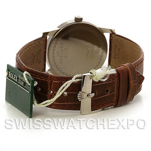 The image shows a rear view of a Rolex Cellini 5116/9 White Gold Beige Dial 5116/9 White Gold Beige Dial watch, highlighting the leather strap, buckle, and attached tags.