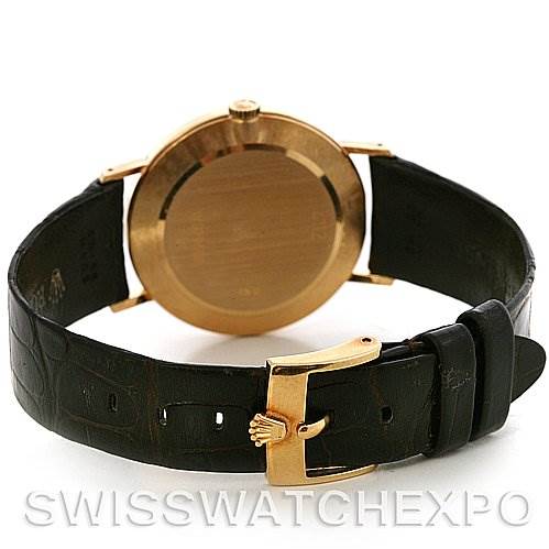 This image shows the back case and black leather strap of a Rolex Cellini 4112 Yellow Gold White Dial 4112 Yellow Gold White Dial model, along with its gold buckle.