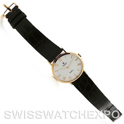 The image shows a Rolex Cellini 4112 Yellow Gold White Dial 4112 Yellow Gold White Dial watch lying flat, displaying its black leather strap, gold case, and white face with Roman numerals.