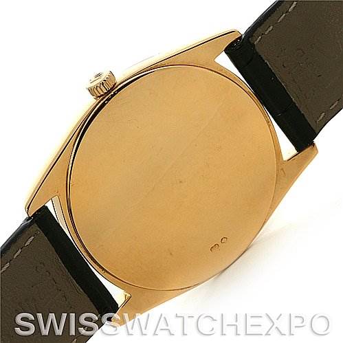 This image shows the back and side of a Rolex Cellini 4233 Yellow Gold White Dial 4233 Yellow Gold White Dial model watch case with its crown and leather strap.