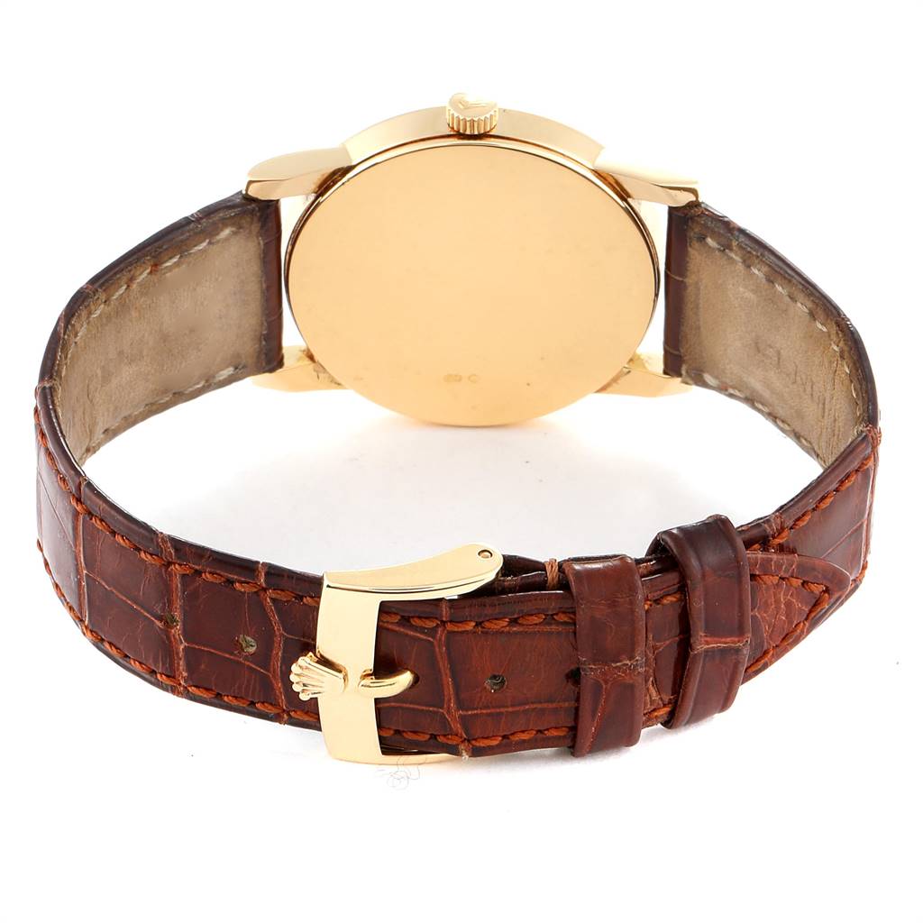 The image shows the back view of a Rolex Cellini 5116 Men's Yellow Gold Silver Dial 5116 Men's Yellow Gold Silver Dial watch, highlighting the gold case and brown leather strap with a gold buckle.