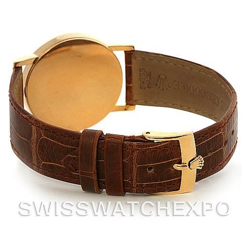 The image shows the back view of a Rolex Cellini 5115 Yellow Gold Black Dial 5115 Yellow Gold Black Dial watch, highlighting the golden case, leather strap, and buckle.