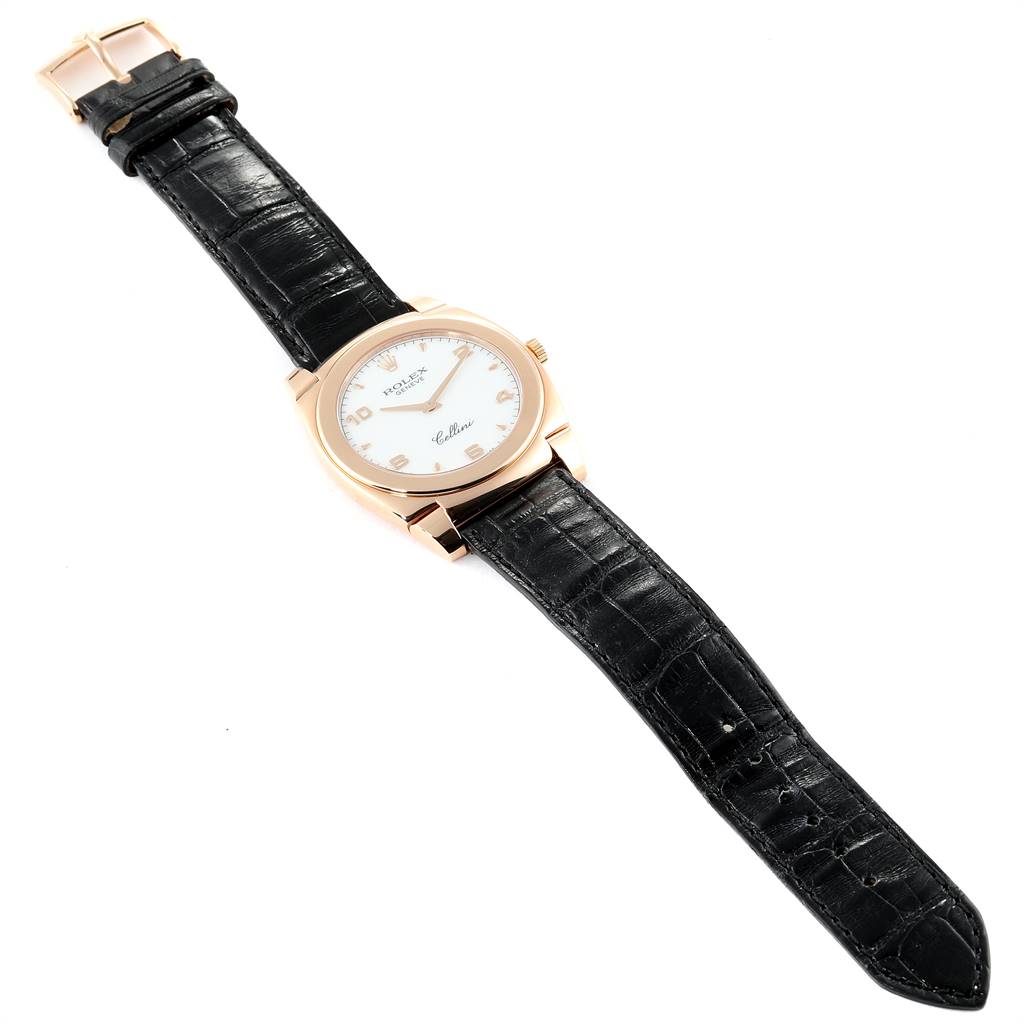 The image shows a top-down view of a Rolex Cellini 5330 Men's Rose Gold White Dial 5330 Men's Rose Gold White Dial watch with a black leather strap and a gold case.