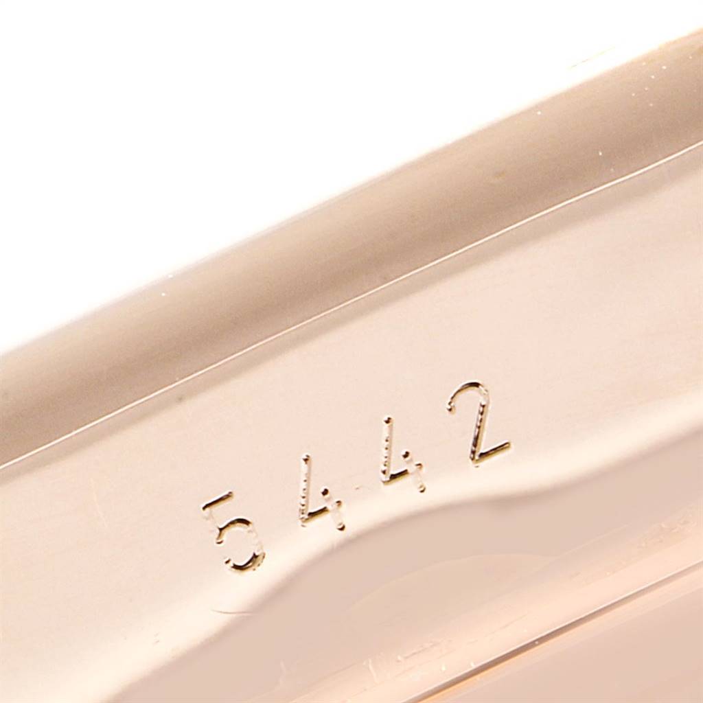 This close-up image shows the engraved serial number on the side of a Rolex Cellini 5442/5 Men's Rose Gold Black Dial 5442/5 Men's Rose Gold Black Dial watch.