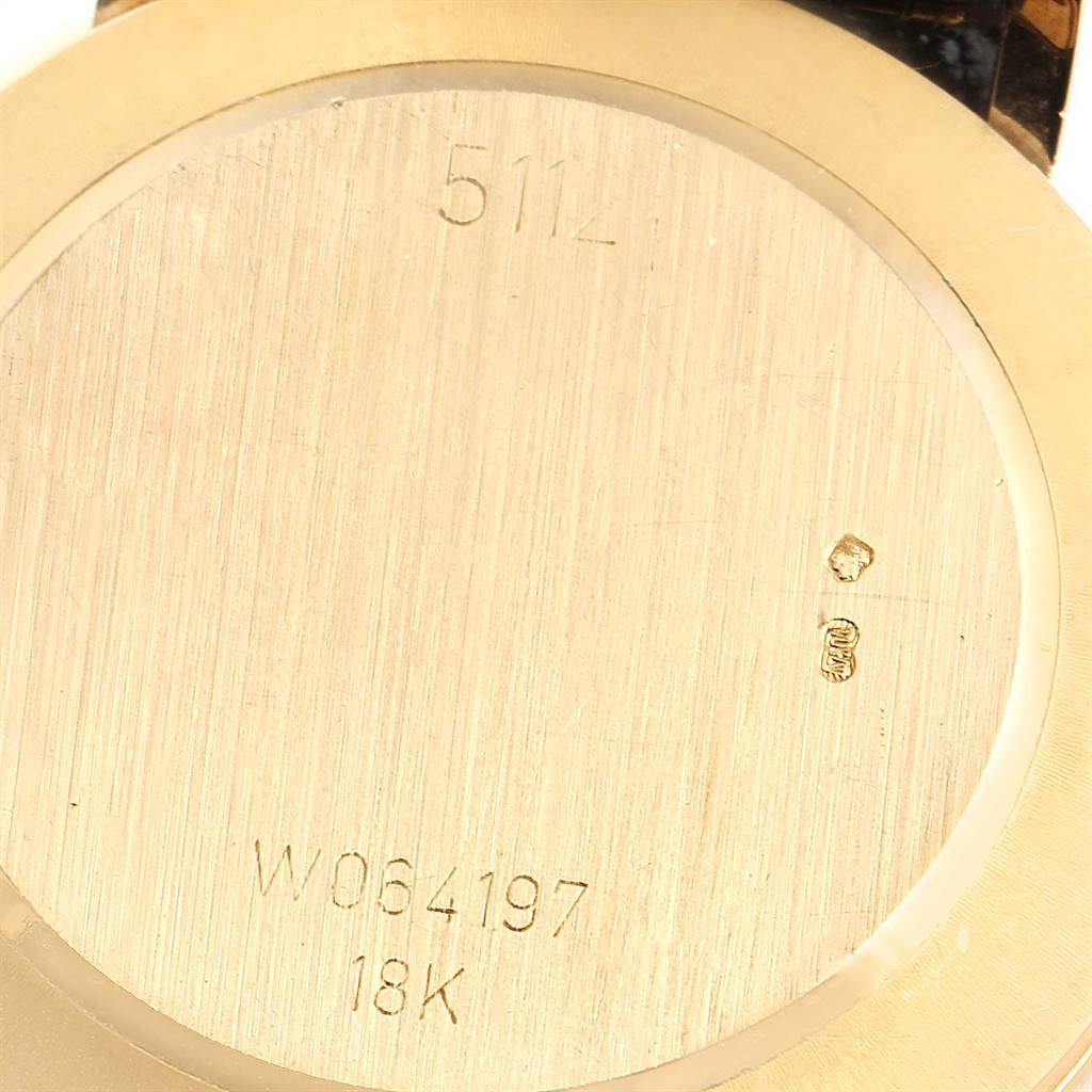 The image shows the back case of a Rolex Cellini 5112 Men's Yellow Gold Beige Dial 5112 Men's Yellow Gold Beige Dial watch, featuring engravings and an 18K gold stamp.
