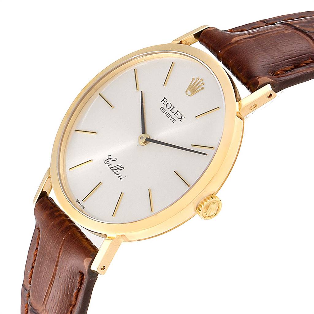 The Rolex Cellini 4112 Men's Yellow Gold Silver Dial 4112 Men's Yellow Gold Silver Dial watch is shown at an angled side view, highlighting its face, crown, and a portion of its brown leather strap.