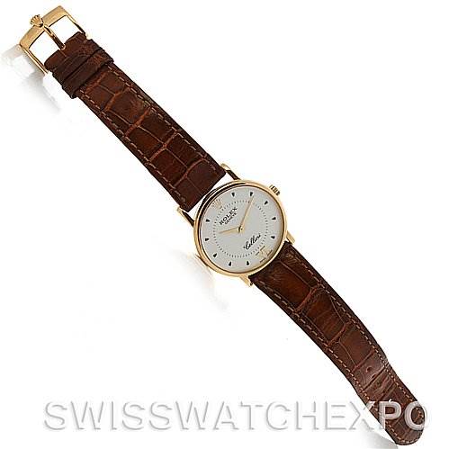 The image shows a top-down view of a Rolex Cellini 5115 Yellow Gold White Dial 5115 Yellow Gold White Dial watch with a brown leather strap and a gold buckle.